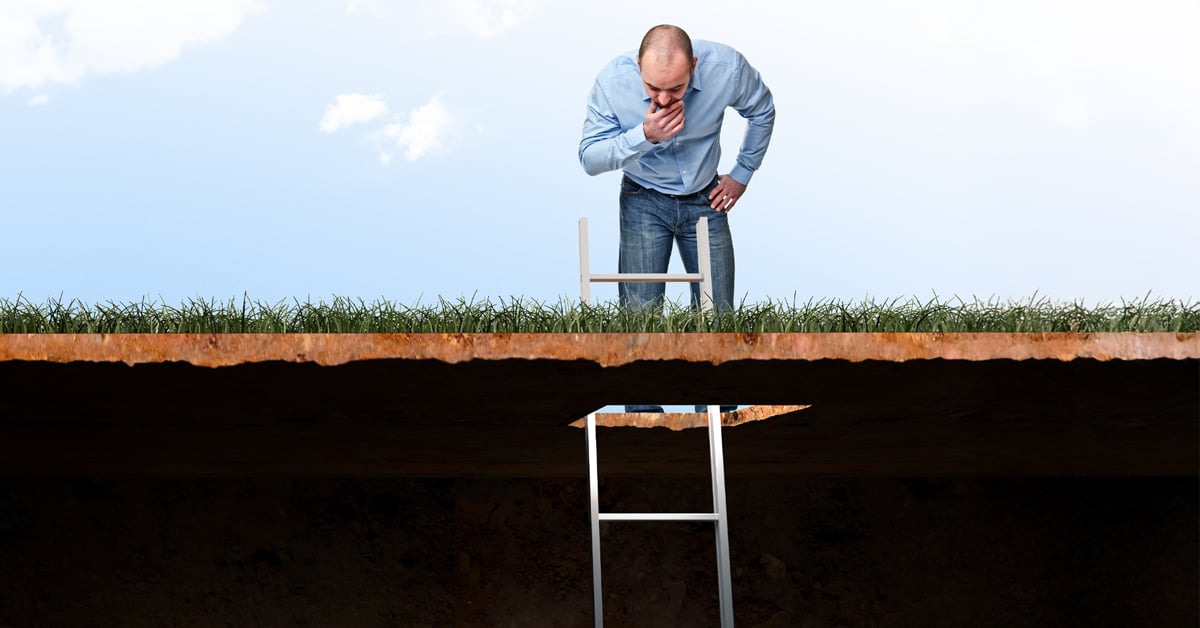 Man looking in hole