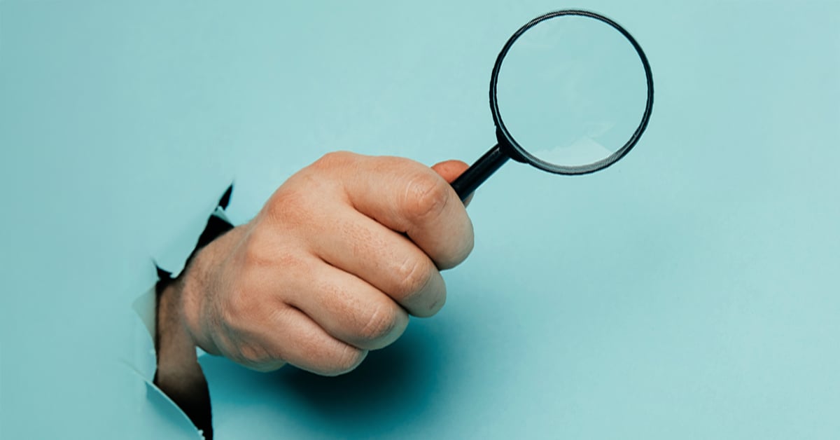Hand holding magnifying glass